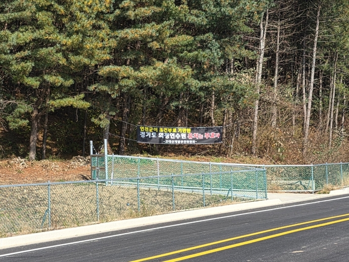 지난 10일 연천군 신서면 고대산 평화체험특구 인근 도로변에 ‘연천군이 조건부를 기만한 경기도의회 연수원 유치는 무효다’라는 문구의 현수막이 걸려 있다. 이석중 기자