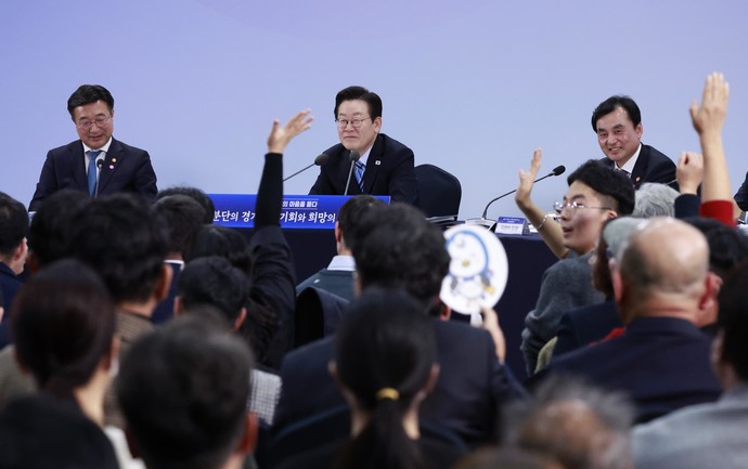 14일 경기 파주시 라이브러리스테이 지지향에서 열린 '경기 북부의 마음을 듣다' 타운홀 미팅 간담회에서 참석자들이 이재명 대통령에게 발언권을 요청하고 있다.  연합뉴스