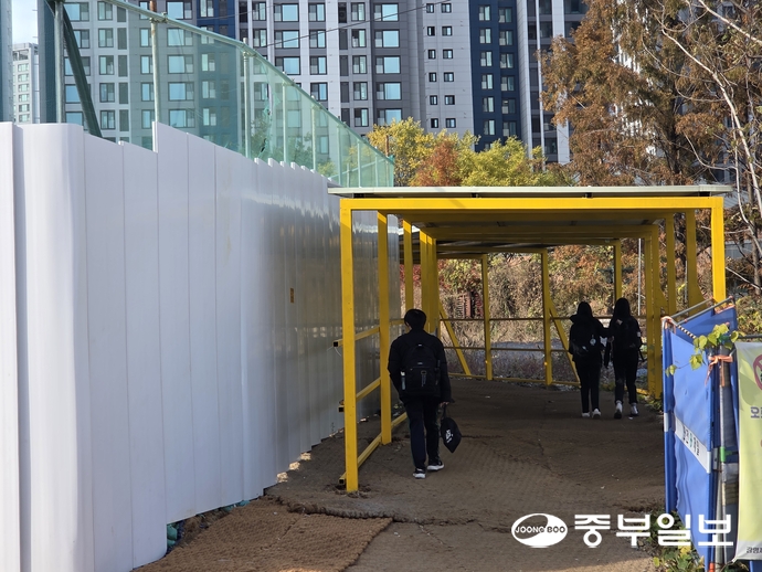 지난 17일 오후 광명시 철산동 현충지하차도 공사현장에 임시로 마련된 보행자 통로로 학생들이 이동하고 있다. 최진규기자