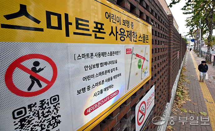 수원시가 관내 초등학교 7곳 대상으로 특정앱 설치시 통학로서 스마트폰 사용 제한하는 블루투스 장치를 설치했지만 앱 설치가 필수적이어서 실효성 문제가 제기되는 가운데 18일 오후 수원시 한 초등학교 인근에 스마트폰 사용제한 스쿨존 안내문이 설치돼 있다. 김경민기자