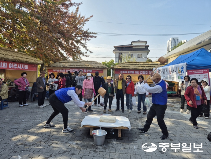 축제장을 찾은 시민들이 관심 있게 지켜보는 가운데 인절미 떡을 만들기 위한 떡메치기가 재현되고 있다. 김규철기자