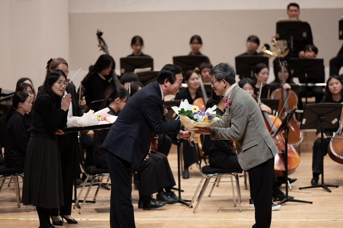 꿈쟁이오케스트라 관계자가 정기연주회에 참석한 후원자에게 꽃다발을 전달하고 있다. 사진=수원시청